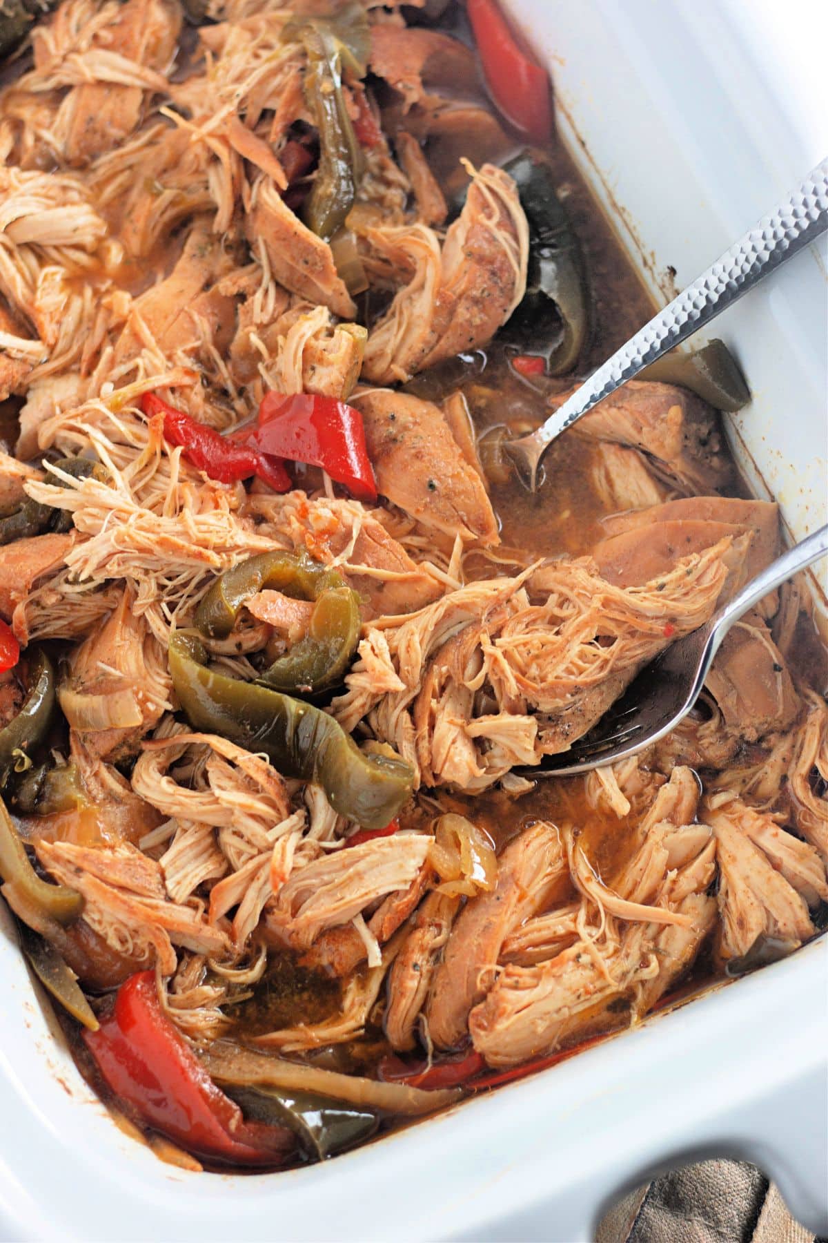 Shredded chicken and peppers in a crockpot.