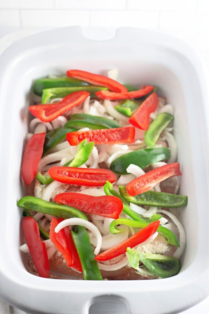Peppers and onions in a slow cooker.