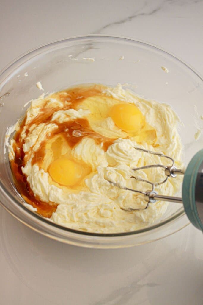 Eggs, vanilla, and butter in a glass mixing bowl.