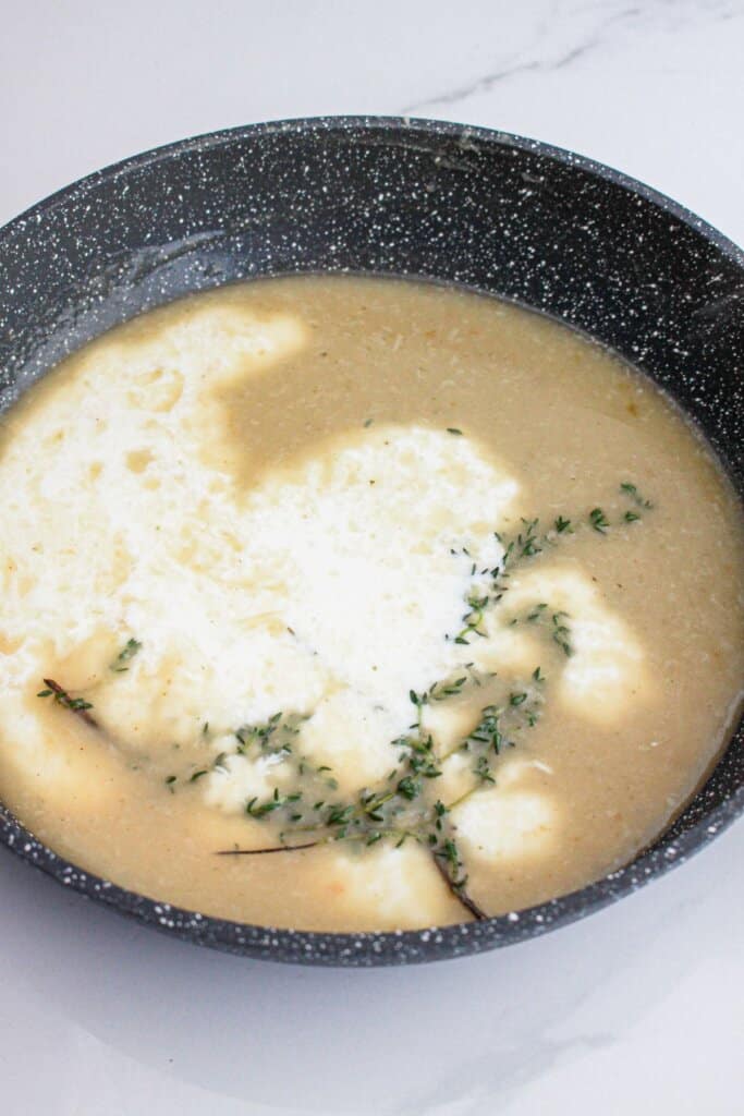 Milk being added to sauce in a skillet.
