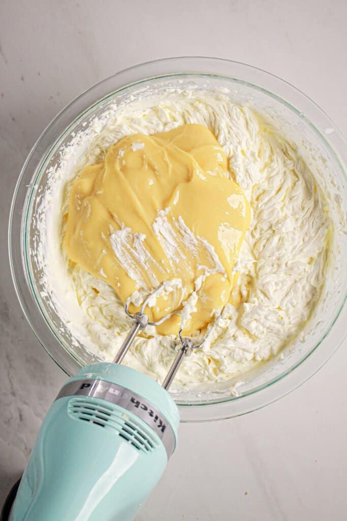 Pudding being added to cream cheese mixture.
