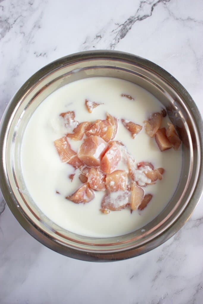 Chicken pieces soaking in buttermilk.