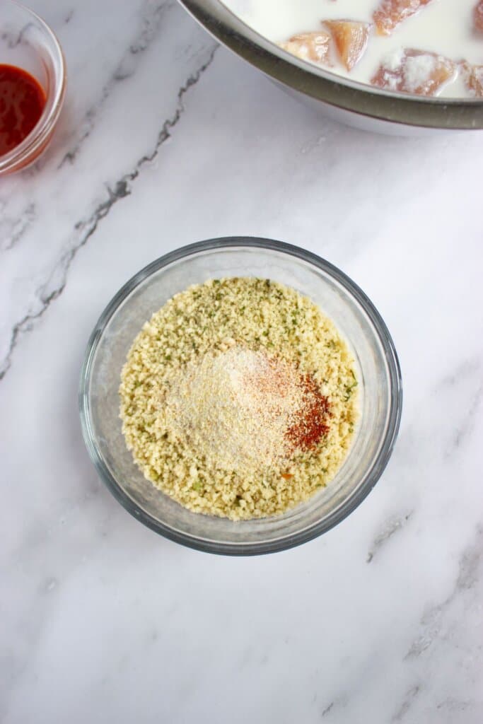 Breadcrumbs and seasonings being mixed in a small bowl.
