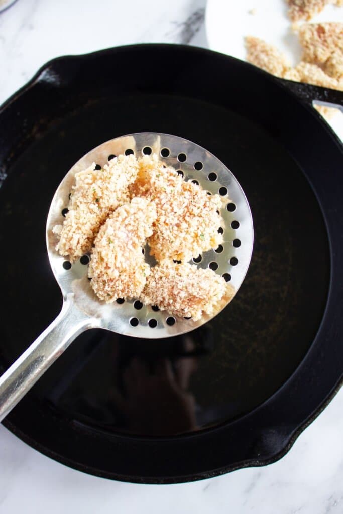 Homemade chicken nuggets being deep fried.