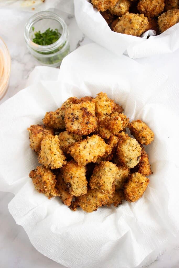 Homemade chicken nuggets in a paper towel lined bowl.