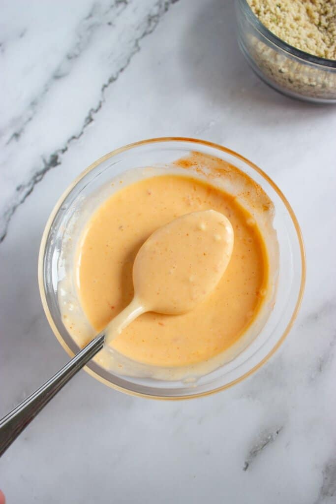 Sauce being mixed in a small glass bowl.