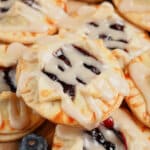 Blueberry pie cookies on a wooden cutting board.