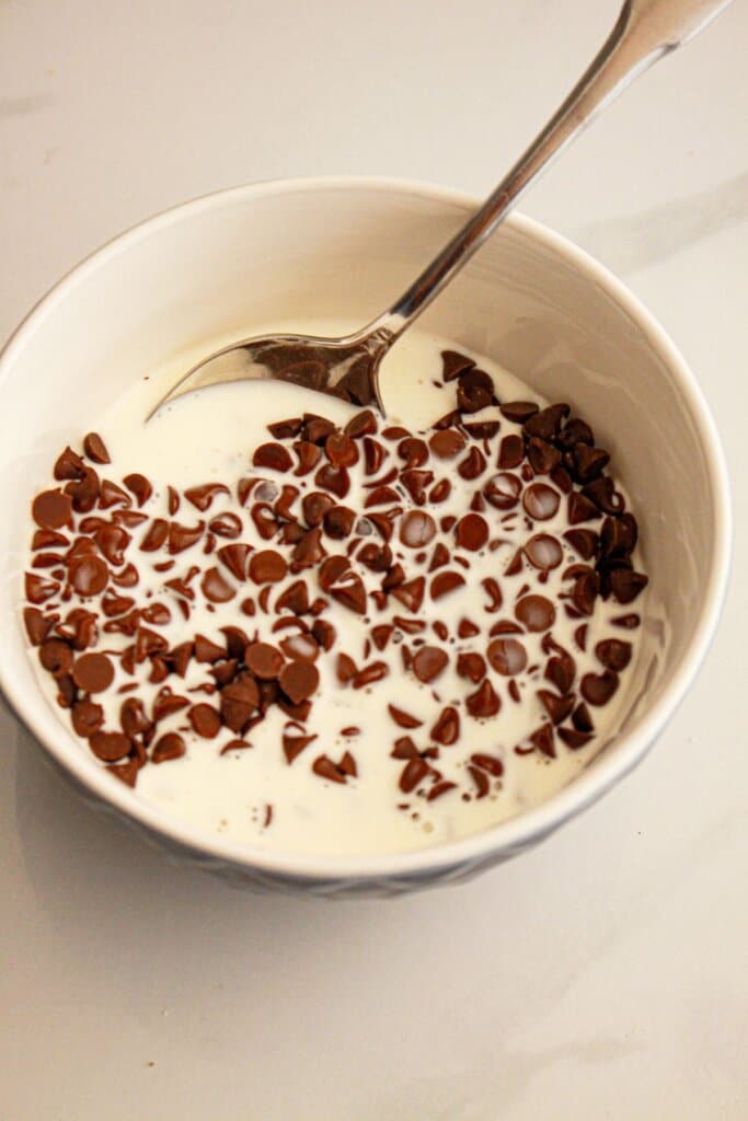 Chocolate ganache being mixed in a bowl.