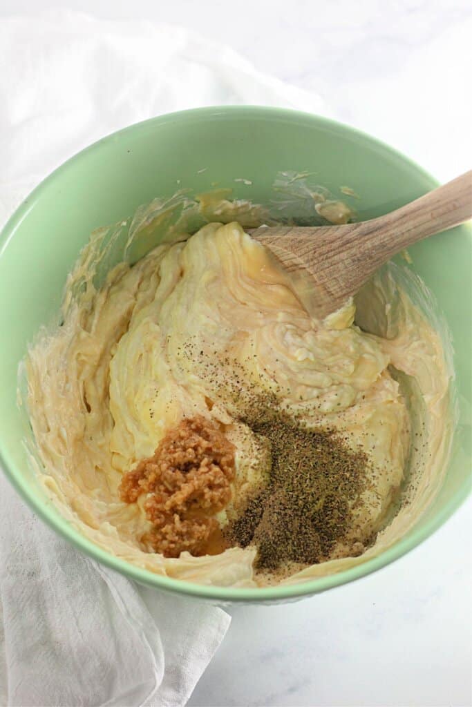 Sour cream, cream of soup, and seasonings being mixed together.