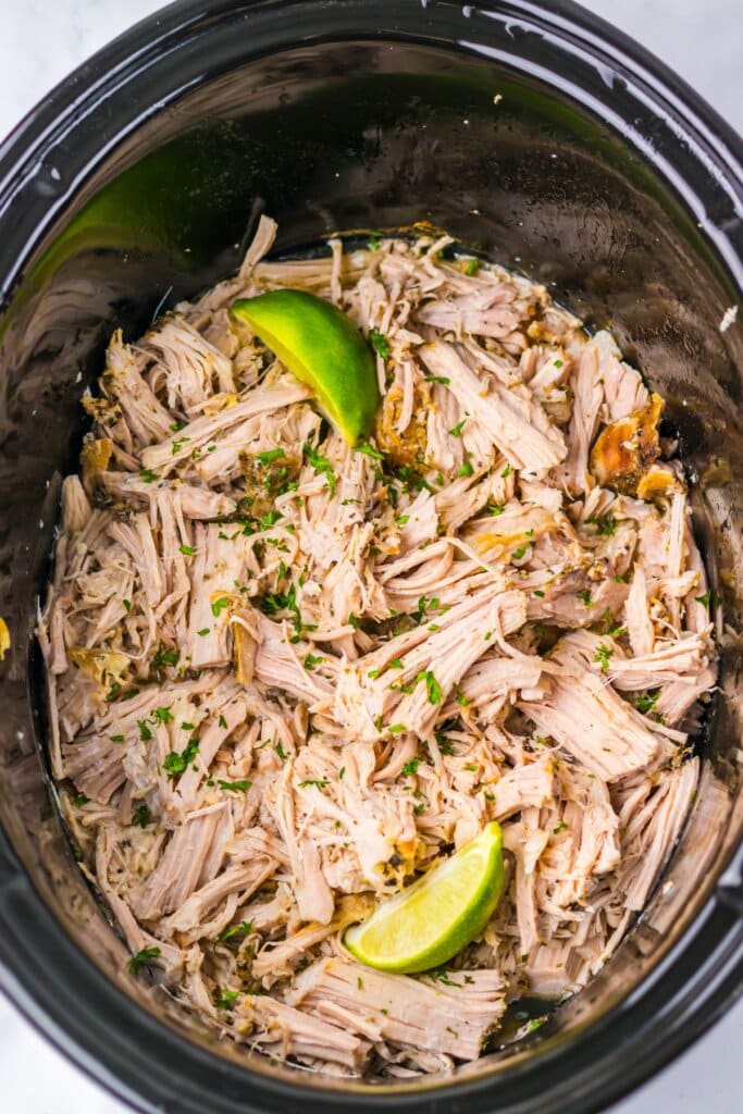 Shredded carnitas meat in a crockpot.