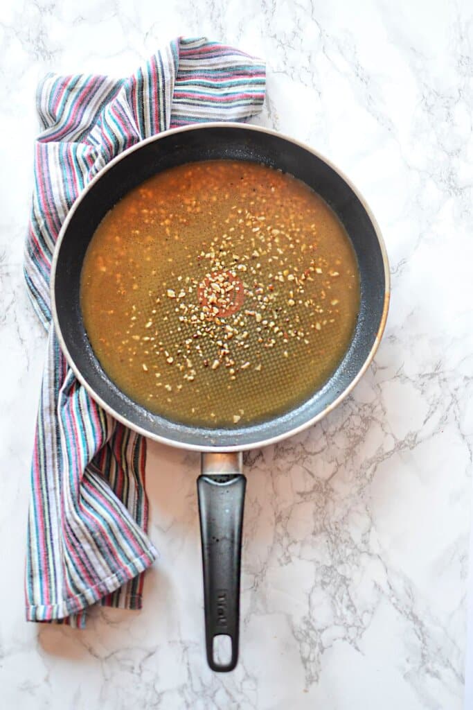 Garlic and stock in a skillet.
