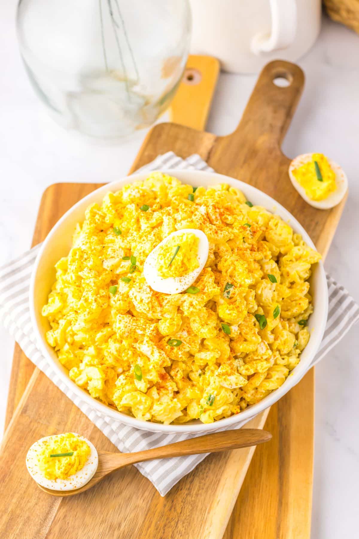 Large white bowl filled with deviled egg pasta salad.