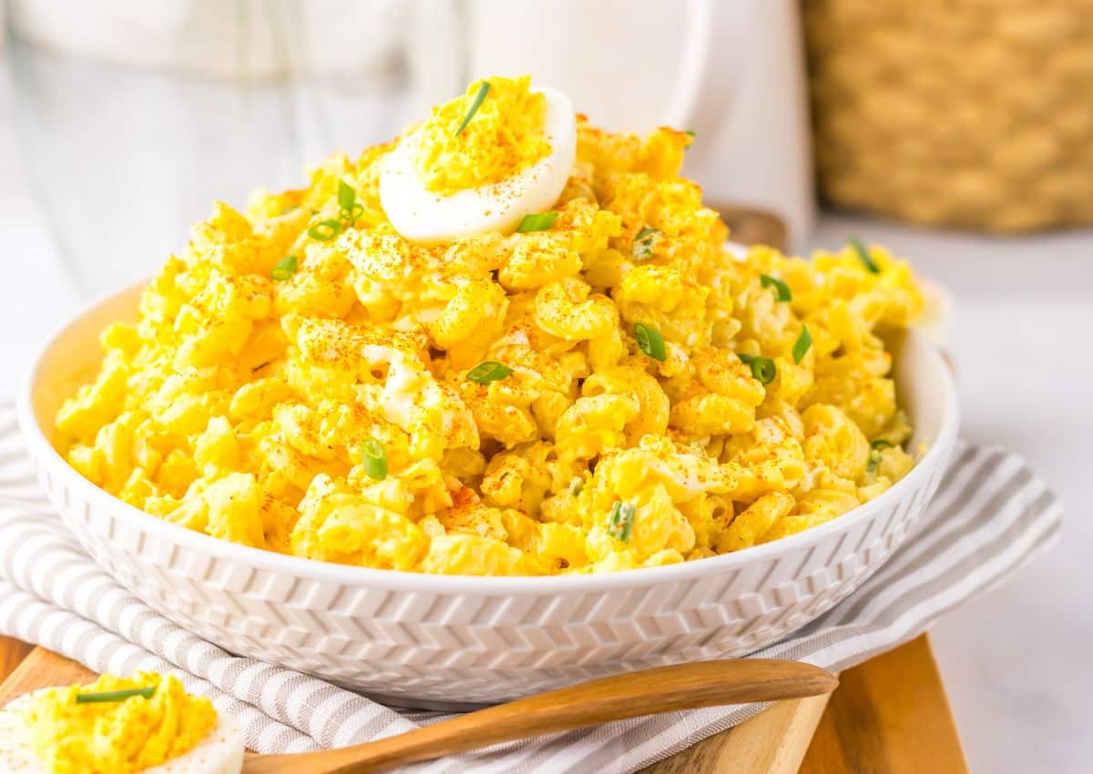White bowl full of deviled egg pasta salad.