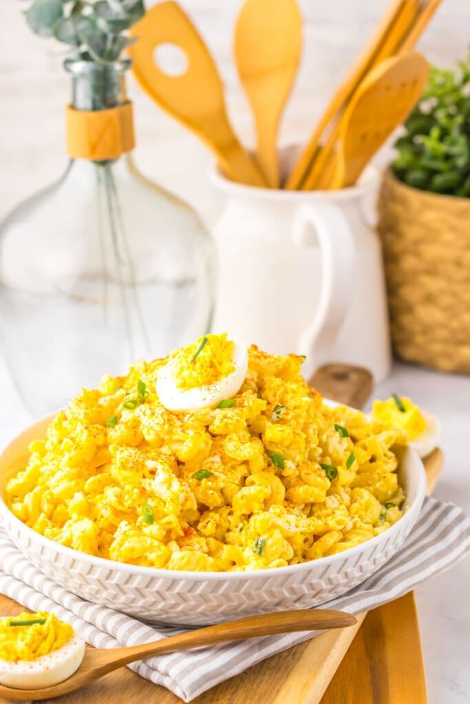 White bowl full of deviled egg pasta salad.