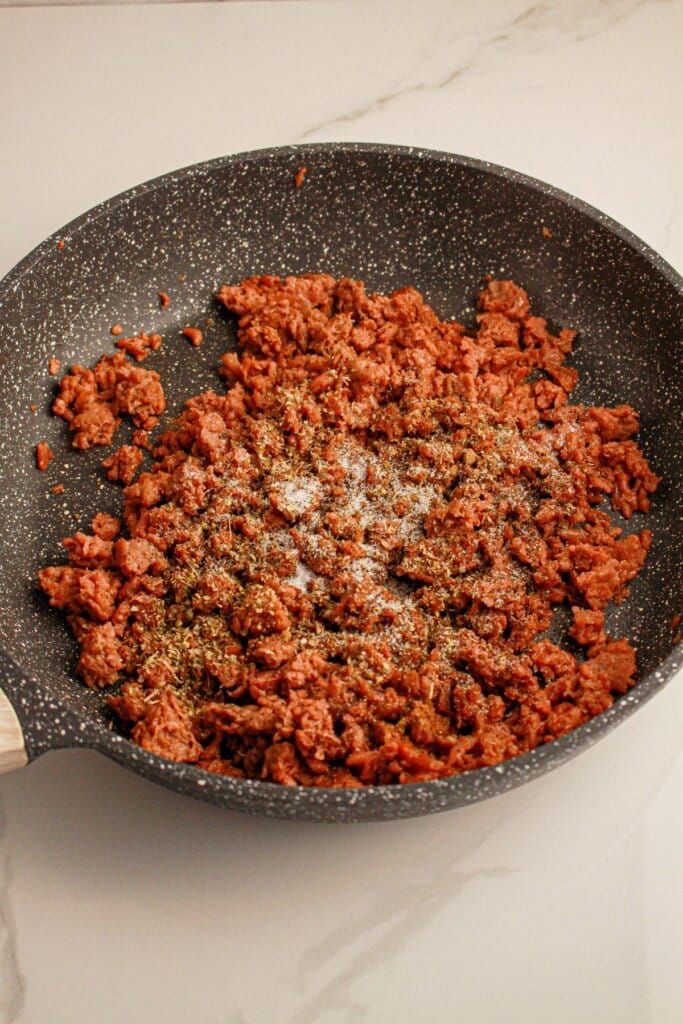Ground beef, salt, and pepper in a skillet.