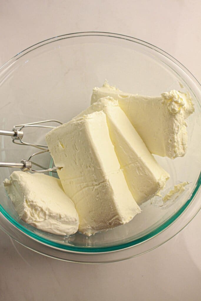 Cream cheese in a glass mixing bowl.