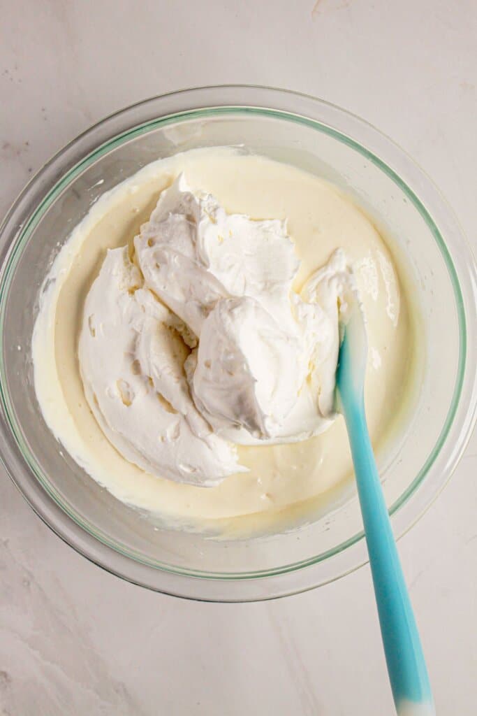 Whipped topping being added to pudding.