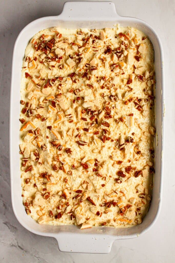Pecans being sprinkled on top of dessert.