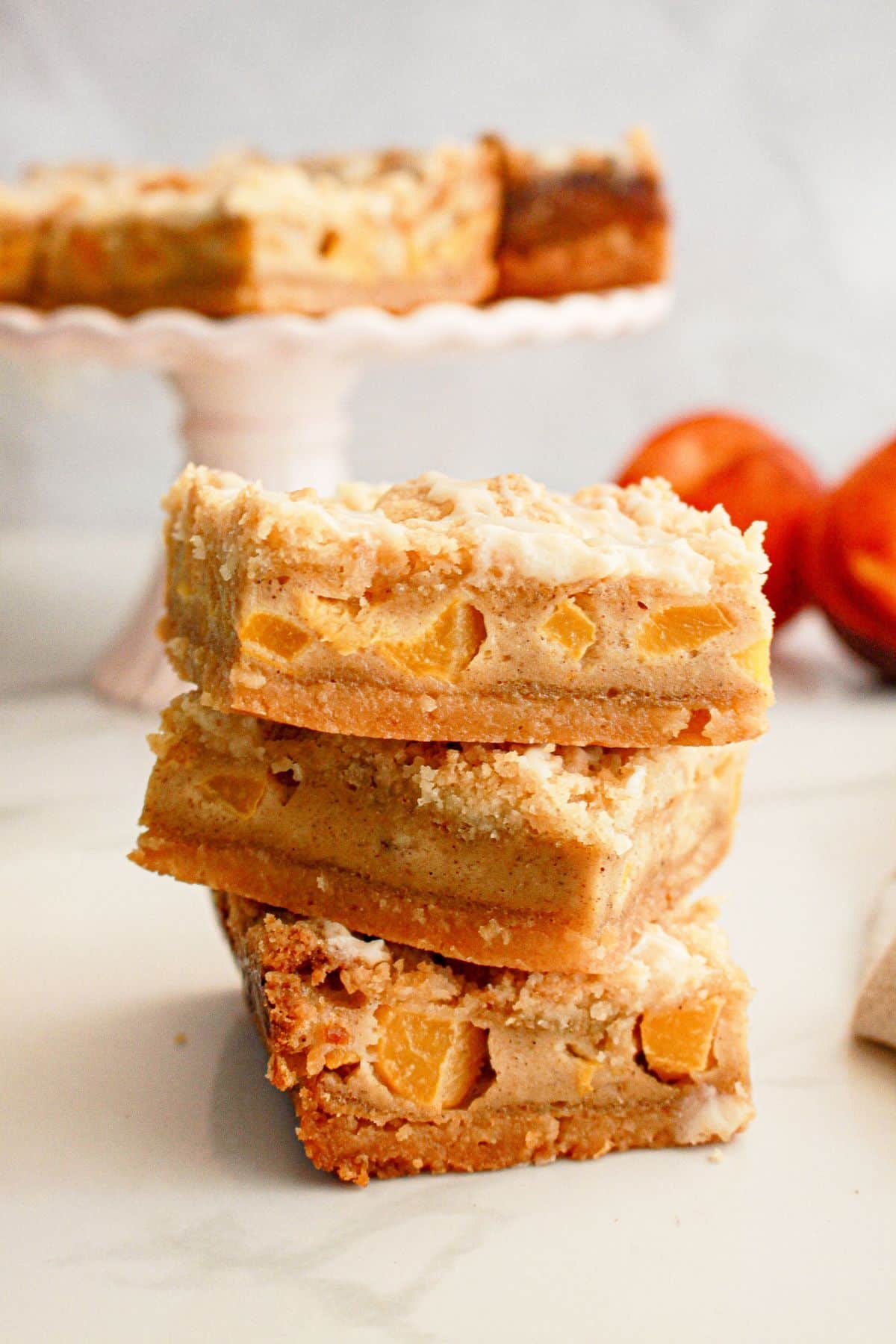 Three peach pie bars stacked on top of each other.