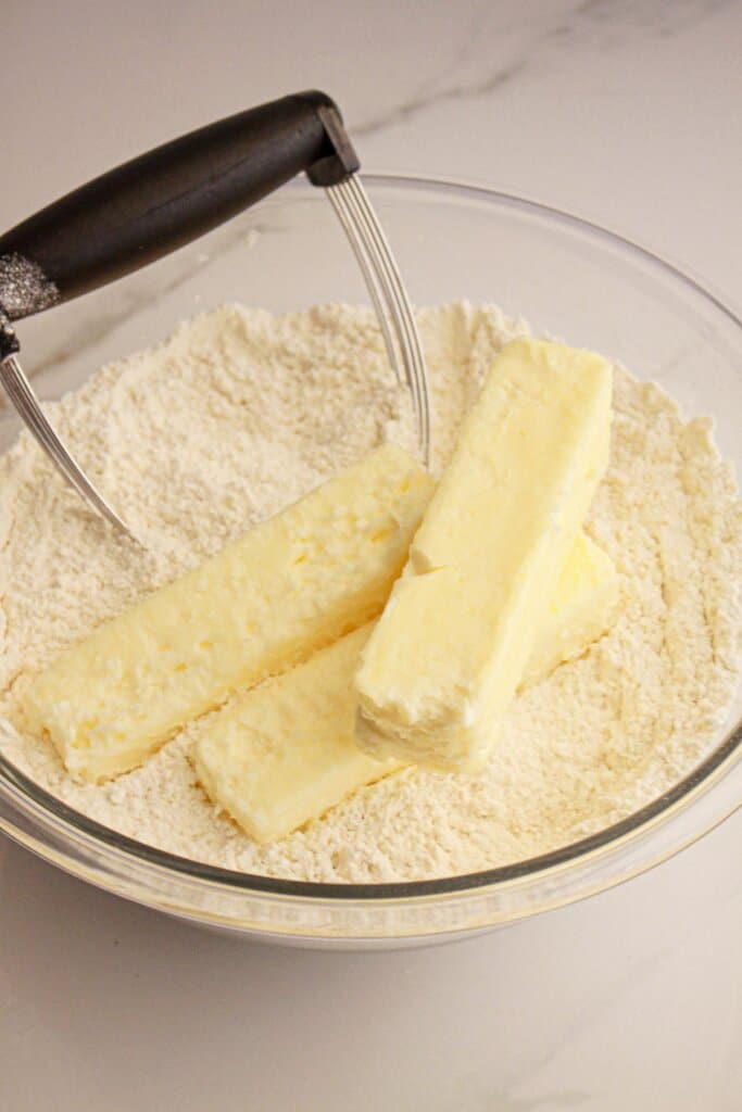 Butter being cut into crust mix.