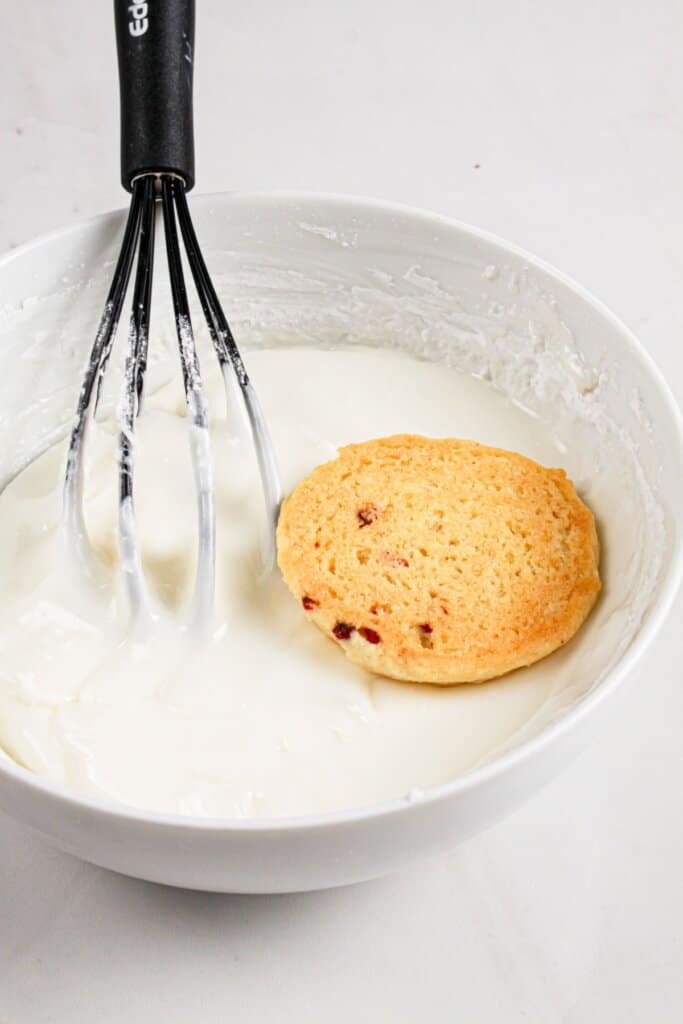 Cookie being dipped in icing.