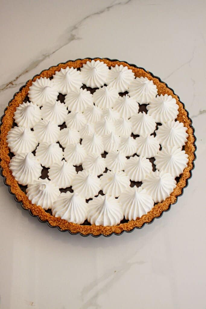 Meringue being piped onto a pie.