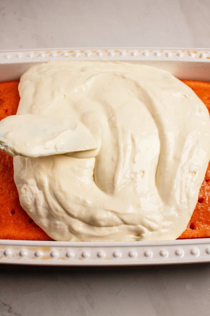 Whipped cream being spread on top of dessert.