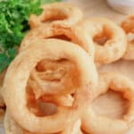 Onion rings on a wooden cutting board.