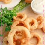 Onion rings on a wooden cutting board.