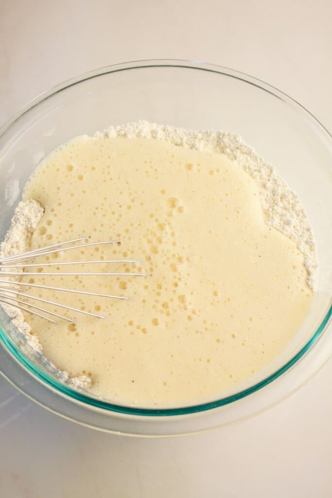 Batter being mixed in a glass bowl.