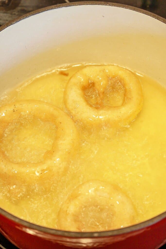 Onion rings being fried in a pot of oil.