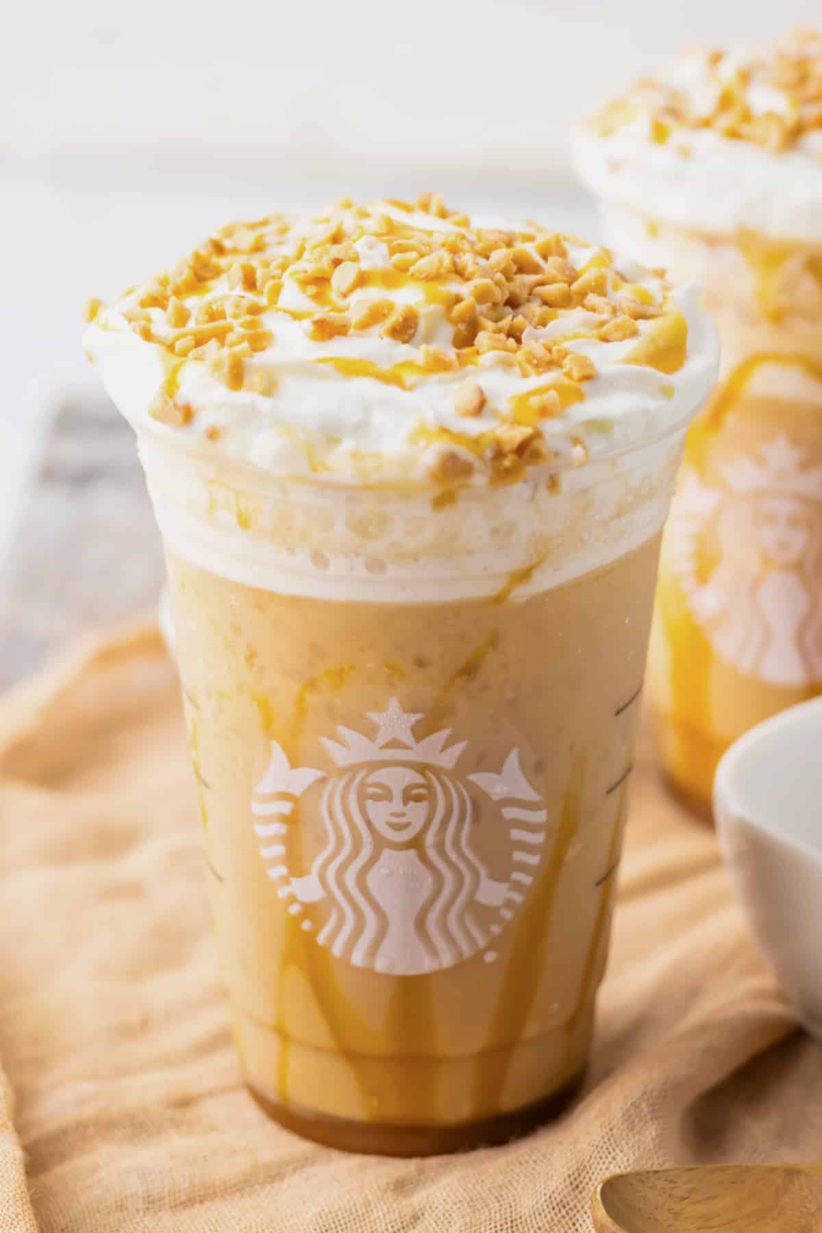 Caramel ribbon crunch Frappuccino in a plastic cup.
