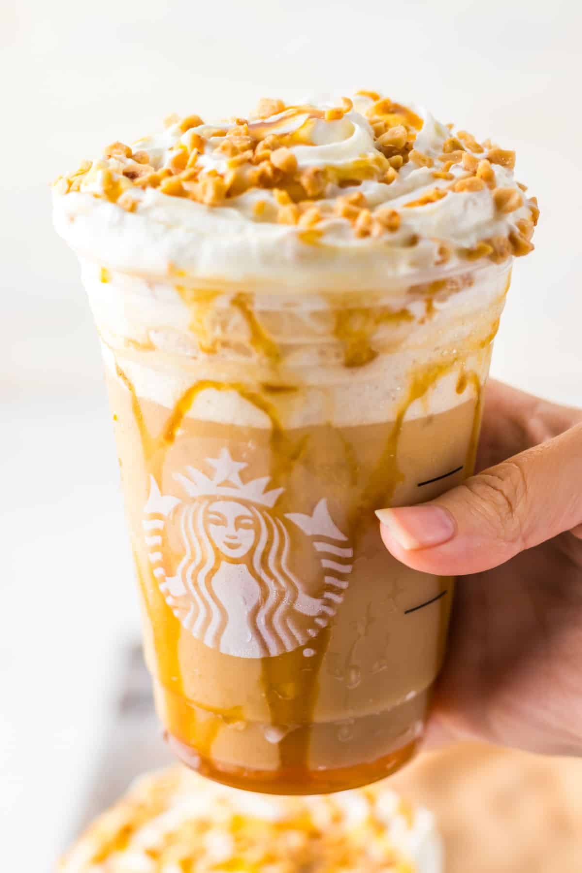 Caramel ribbon crunch Frappuccino in a plastic cup.