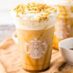 Caramel ribbon crunch Frappuccino in a plastic cup.