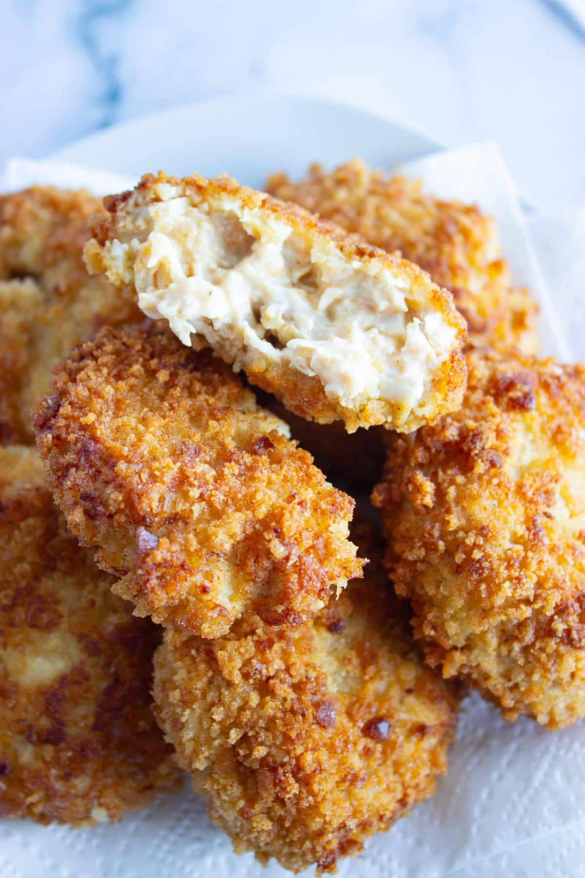 Chicken croquettes stacked on a plate.