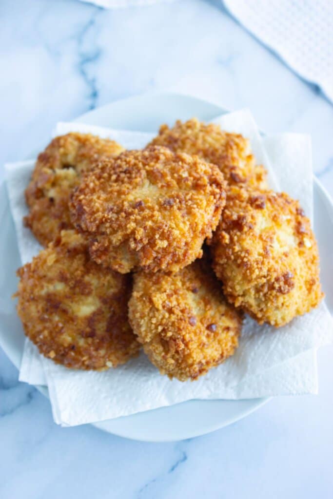 Patties draining on a paper toweled lined plate.