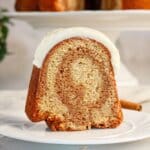 Slice of cinnamon roll bundt cake being removed from cake.