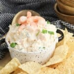 Bowl full of seafood dip surrounded by chips.