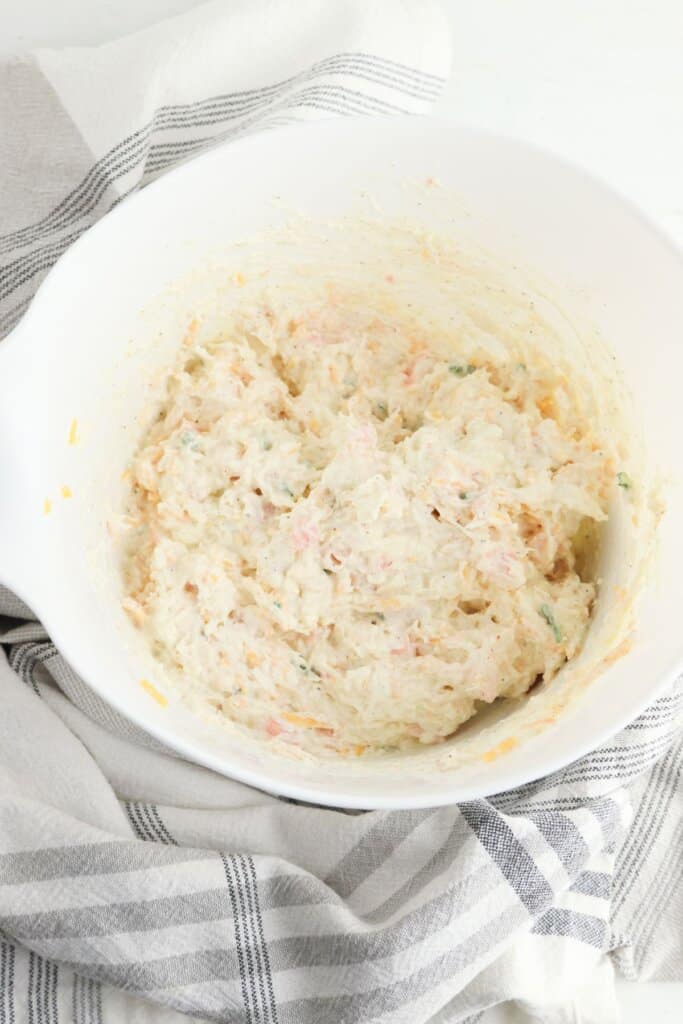 Ingredients being mixed in a white bowl.