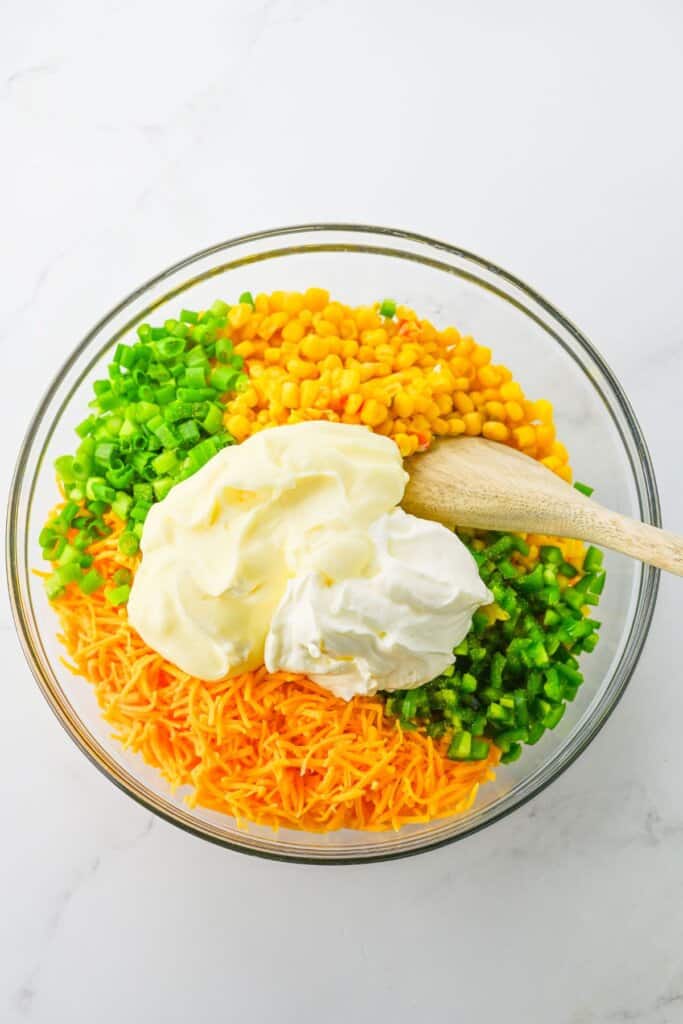 All the ingredients being added to a large glass mixing bowl.