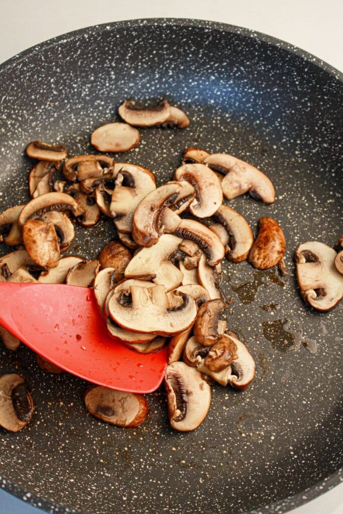 Mushrooms being cooked in a skillet.