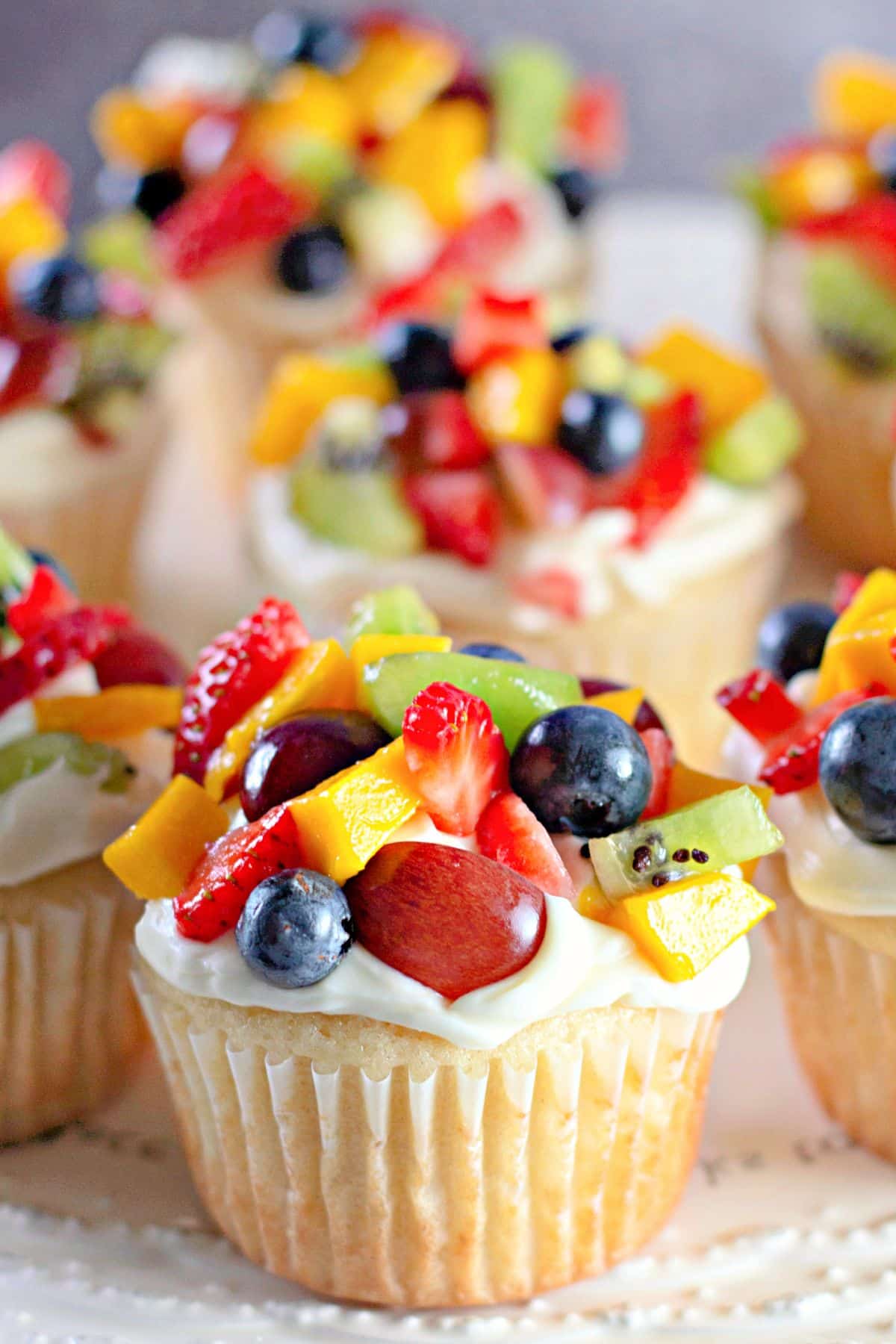 Fruit pizza cupcakes on a counter.