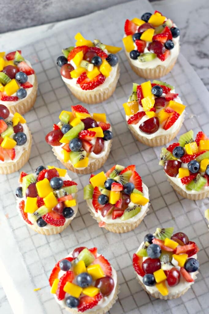Fruit cupcakes on a cooling rack.