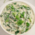 White bowl full of homemade creamed spinach.