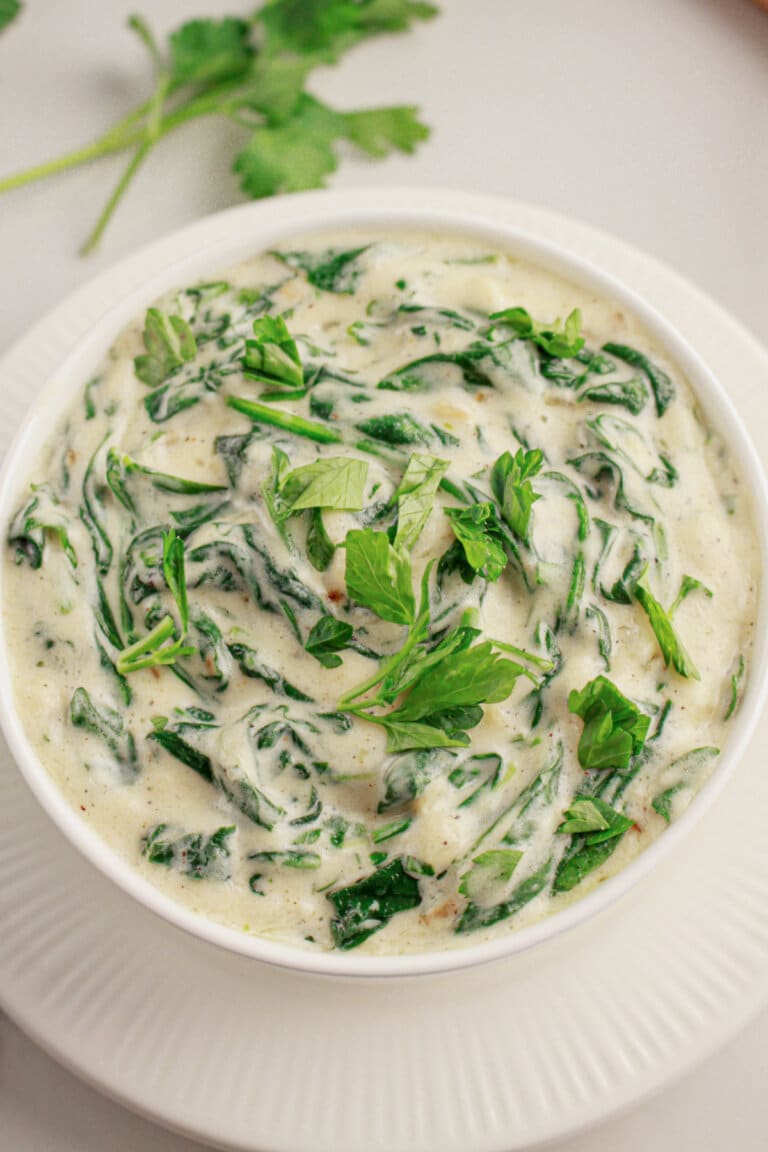 White bowl full of homemade creamed spinach.
