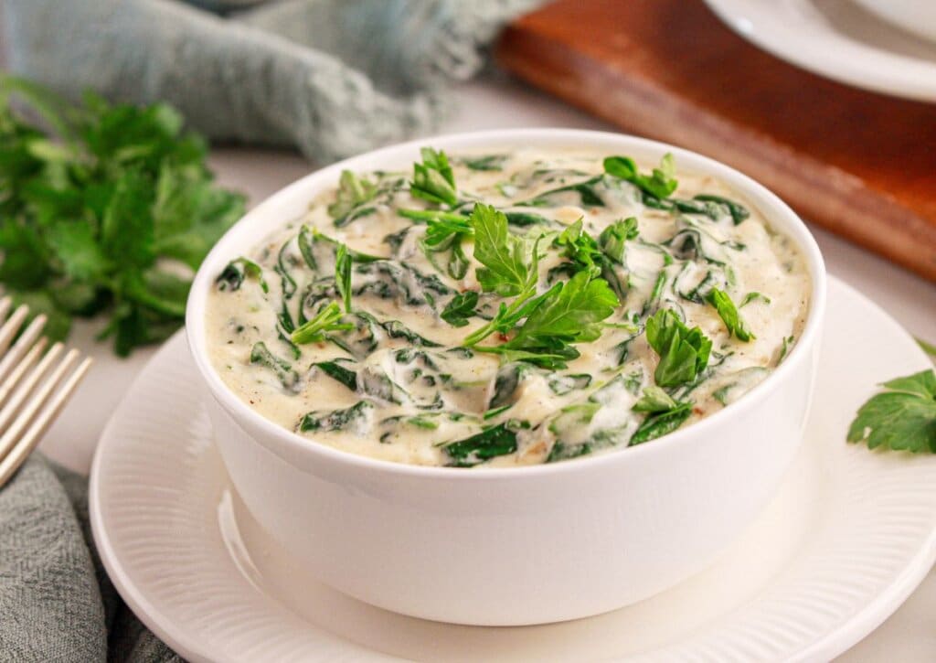 White bowl full of homemade creamed spinach.