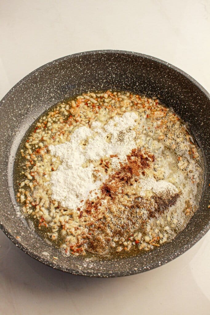 Flour being browned for a roux in a skillet.
