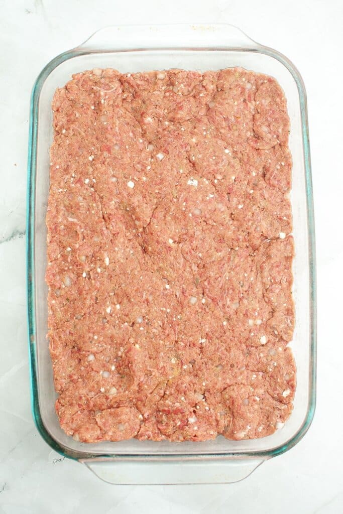 Meatloaf pressed into a baking dish.