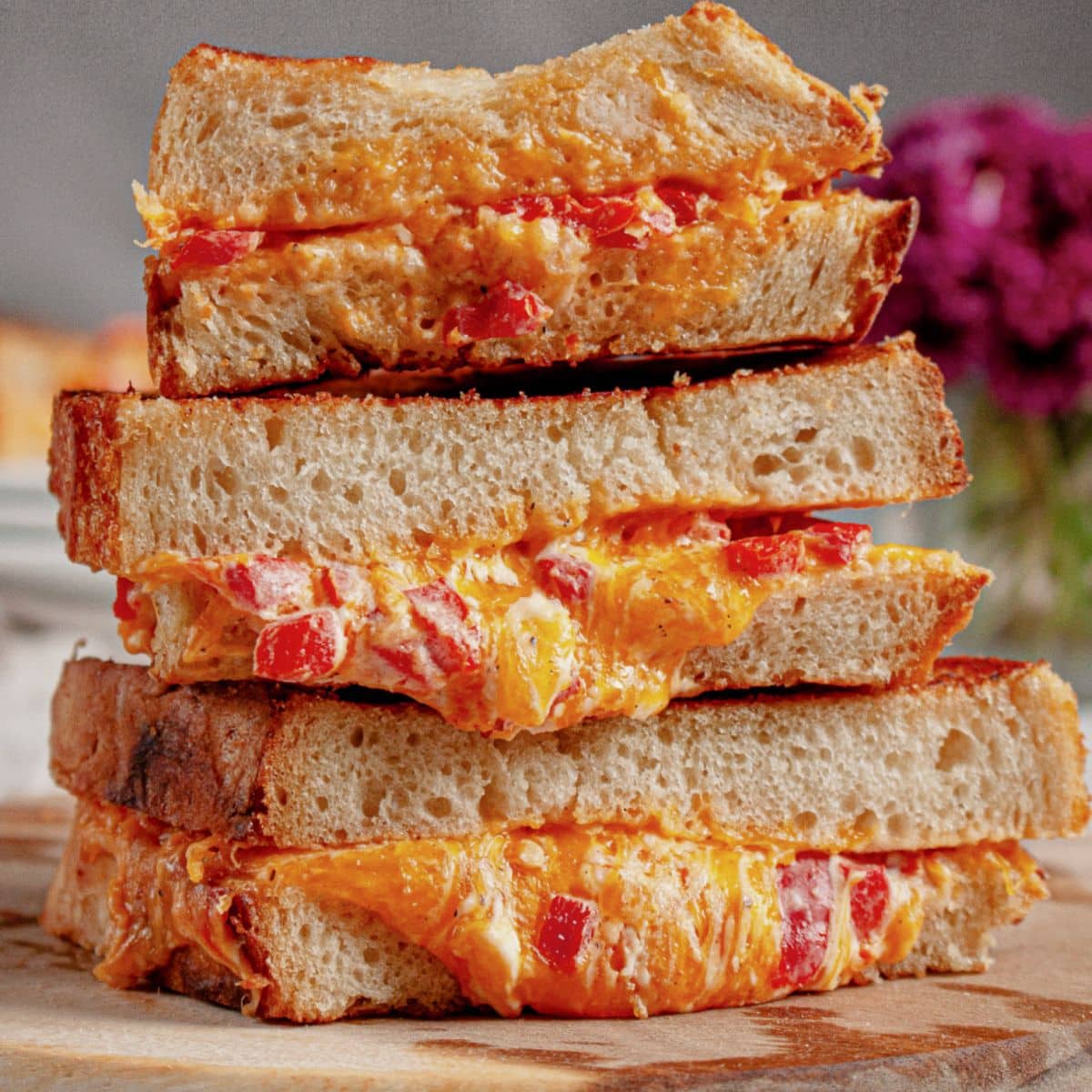 Three pimento grilled cheese sandwiches stack on top of each other.
