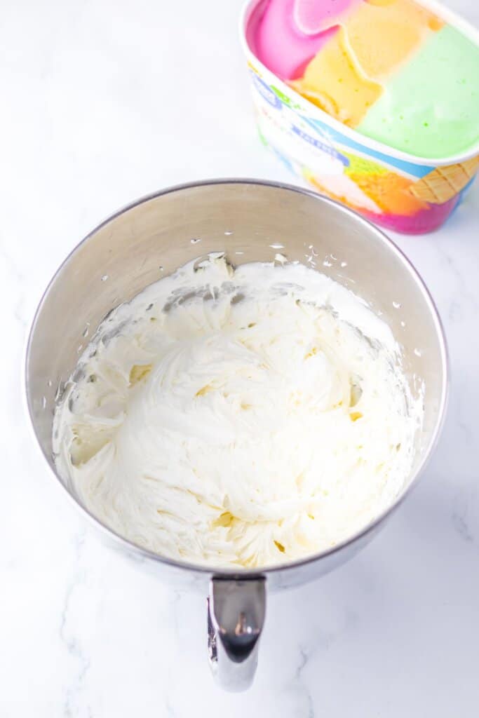 Whipped cream in a stainless steel mixing bowl.